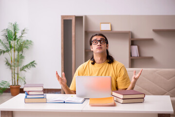 Young male student preparing for exams at home