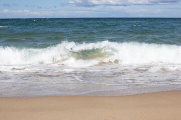 Aerial view of sandy beach and ocean with waves.