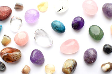 Obraz na płótnie Canvas Gems of different colors. Amethyst, rose quartz, agate, apatite, aventurine, olivine, turquoise, aquamarine, rhinestone lie on a white background
