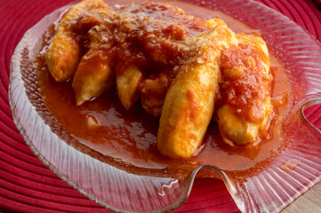 Quenelles from Lyon prepared with tomatoes, onion and aromatic herbs sauce