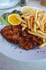 Wiener Schnitzel served with french fried potato and fresh salad