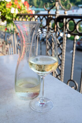 Tasting of white quality riesling wine served on outdoor terrace in Mosel wine region and old...