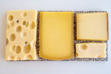 Cheese collection, hard French cheeses comte and emmentaler with round holes made from cow milk