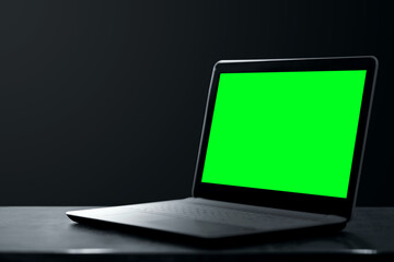 Fototapeta premium Creative background dark laptop stands on a dark background. Modern technology concept.