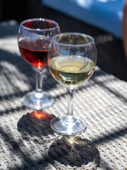 Two glasses of cold rose and white wines in lounge bar on sunny day