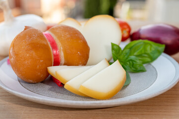 Cheese collection, variety of Italian cow milk cheese scamorza with Italian houses on background