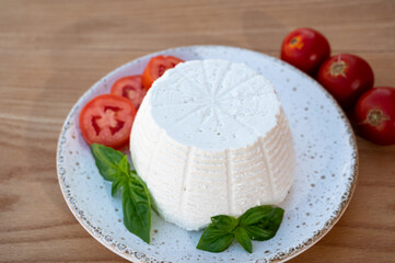 Cheese collection, white Italian soft cheese ricotta served with fresh tomatoes and basil