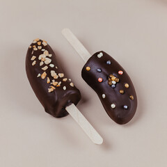 Two bananas in chocolate on sticks are decorated