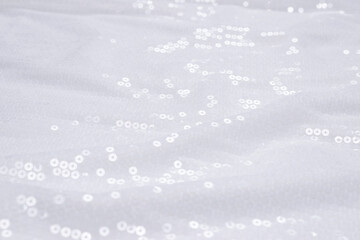 White sequin background. White shiny sequin fabric.