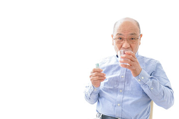 薬を飲む高齢男性