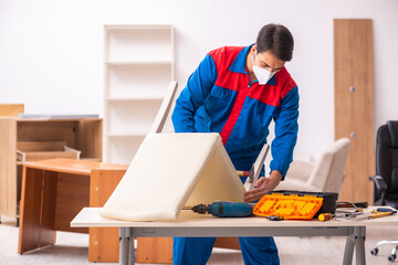 Young male carpenter working in the office during pandemic