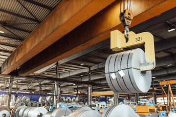 Overhead crane hook lifting rolled up metal sheet