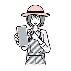 立ってスマートフォンを指差してこちらに向けて見せている農家の女性