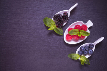 ripe berry in a white dish - blackberries, raspberries and blueberries