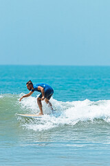 Mężczyzna surfer płynący na fali na tle błękitnego oceanu i nieba. © insomniafoto
