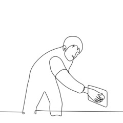 man throws a ball into a square hole - one line drawing vector. concept man throws out trash