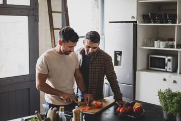 Hispanic male couple cooking in kitchen