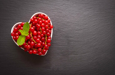 ripe red currant berry in a heart shaped dish