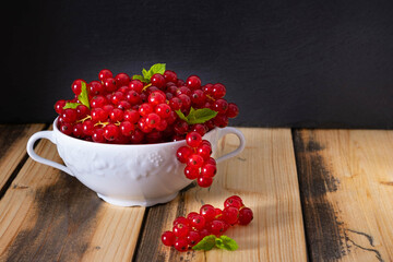 ripe fragrant currants in a white dish, on a wooden table