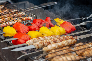 Spit meat and vegetables are fried over an open fire. BBQ meat and vegetables