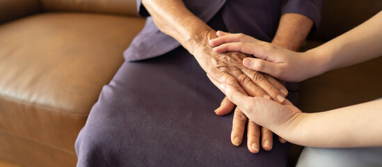 Caregiver and eldery woman holding hands. Support of nursing family caregiver. Senior services and geriatric care concept. - obrazy, fototapety, plakaty