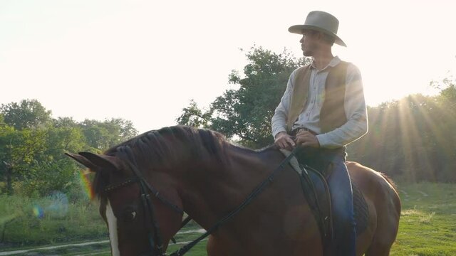 American cowboy on horseback on a forest lawn