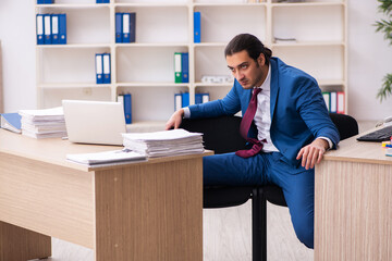Young male employee in multitasking concept