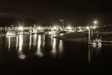 Harbor with ships and lights taken at night in black and white