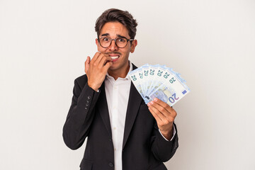 Young mixed race business man holding bills isolated on white background biting fingernails, nervous and very anxious.