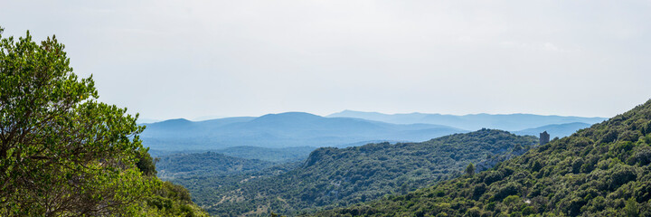 Ruined Medieval Tower with mountanious panorama on the background, Pic Saint Loup, Herault, France