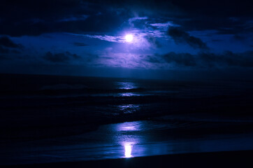 Fototapeta na wymiar Mar durante a noite com a luz do luar refletindo nas águas