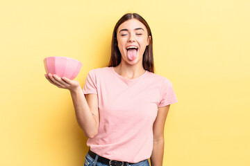 young hispanic woman with cheerful and rebellious attitude, joking and sticking tongue out. empty...