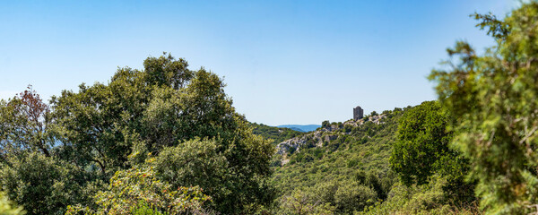 Ruined Medieval Tower with mountanious panorama on the background, Pic Saint Loup, Herault, France