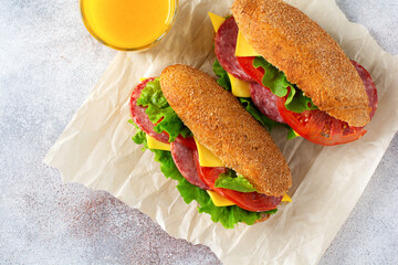 Healthy sandwiches with bran bread, green lettuce, cheese, red tomato and sliced salami on...