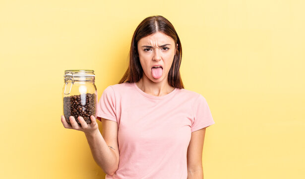 young hispanic woman feeling disgusted and irritated and tongue out. coffee beans concept