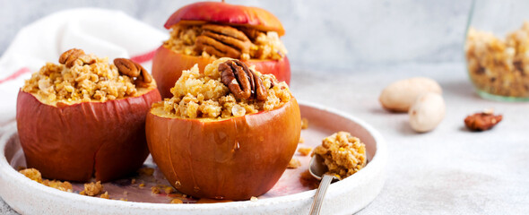 Baked Apples Stuffed with pecans, cinnamon, streyzel and honey on old concrete light background....