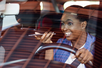 Young businesswoman commuting to work and talking on mobile phone while driving a car. Businesswoman making a phone call while driving to work.