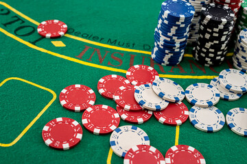 on the green poker table are playing cards, and lots of colored chips