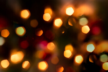 Defocused abstract yellow bokeh lights of garland on a black background. Christmas and New Year's atmosphere