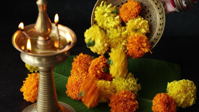 Indian woman decorating flowerbed marigold flower lighted oil lamp Pongal Onam Diwali vishu celebration Indian festival Nilavilakku 4K video footage Rangoli Kerala Tamil nadu North India Mumbai Delhi