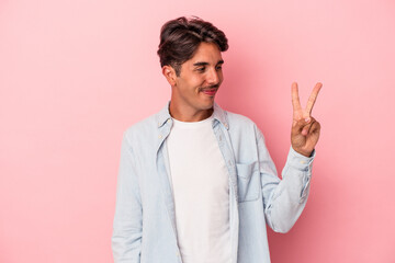 Young mixed race man isolated on white background joyful and carefree showing a peace symbol with fingers.