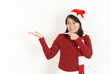 Showing and presenting product on open palm of Beautiful Asian Woman Wearing Red Turtleneck and Santa Hat Isolated On White Background