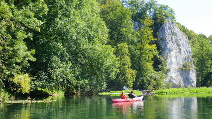 junges Paar im Kajak unterwegs im oberen Donautal mit Auenlandschaft und Kalksteinfelsen