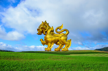 Singha or Lion golden statue on blue sky background in chiang rai thailand. - obrazy, fototapety, plakaty