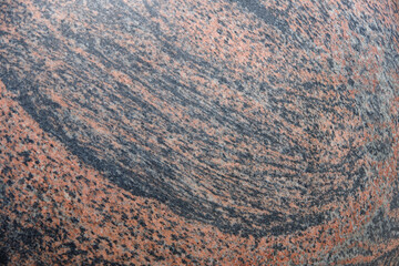 Full frame close-up view of a brown and black marbled granite stone surface with a variety of patterns