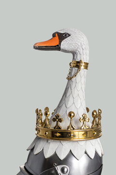 Medieval knightly Milanese helmet with a heraldic kleinod in the form of a swan and a crown, period of the 15th century, on a light background.