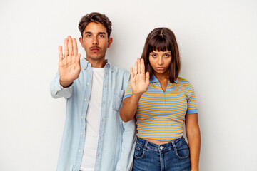 Fototapeta premium Young mixed race couple isolated on white background standing with outstretched hand showing stop sign, preventing you.