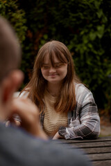 Young woman with Down Syndrome playing cards outdoors and looking happy