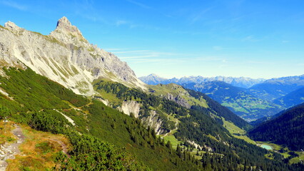 Gipfel der Zimba im Vorarlberg mit weitem Blick ins Montafon mit grünen Tälern unter blauem Himmel