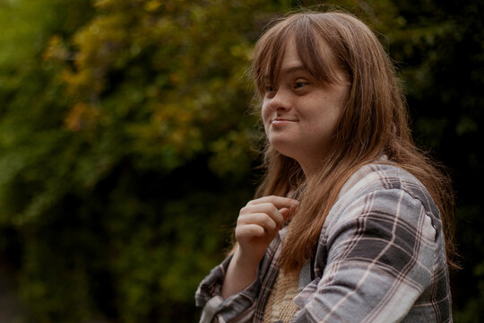 Portrait of young woman with Down Syndrome looking surprised outdoors